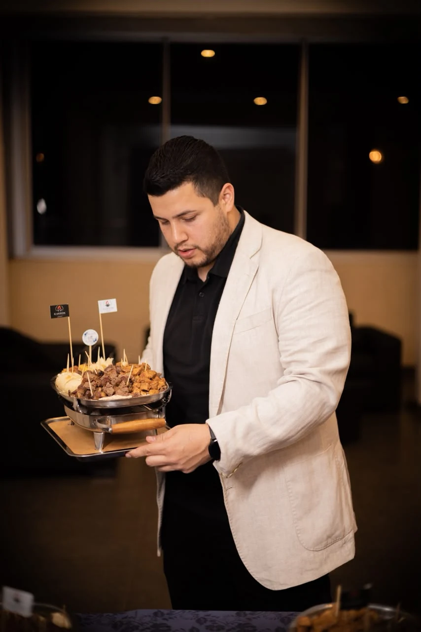 Gastón presentando una parrilla de carnes durante un evento